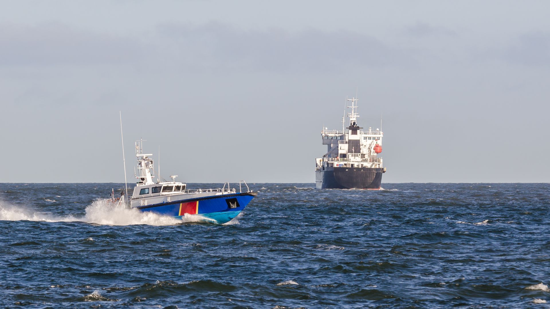 Two boats are floating on top of a large body of water.