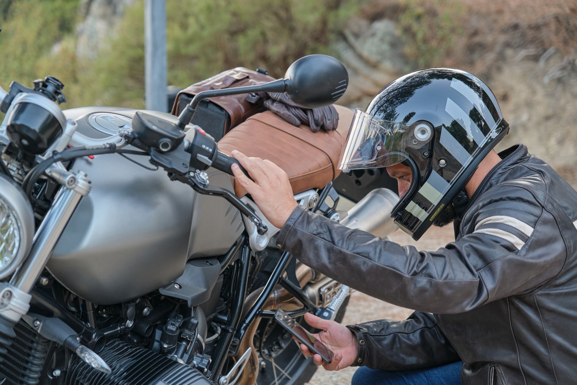 A man wearing a helmet is working on a motorcycle.