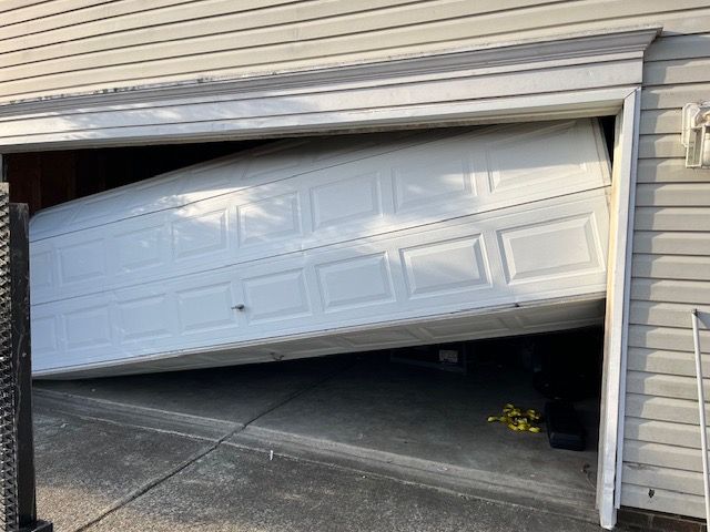 Garage door stuck crooked due to broken spring or cable