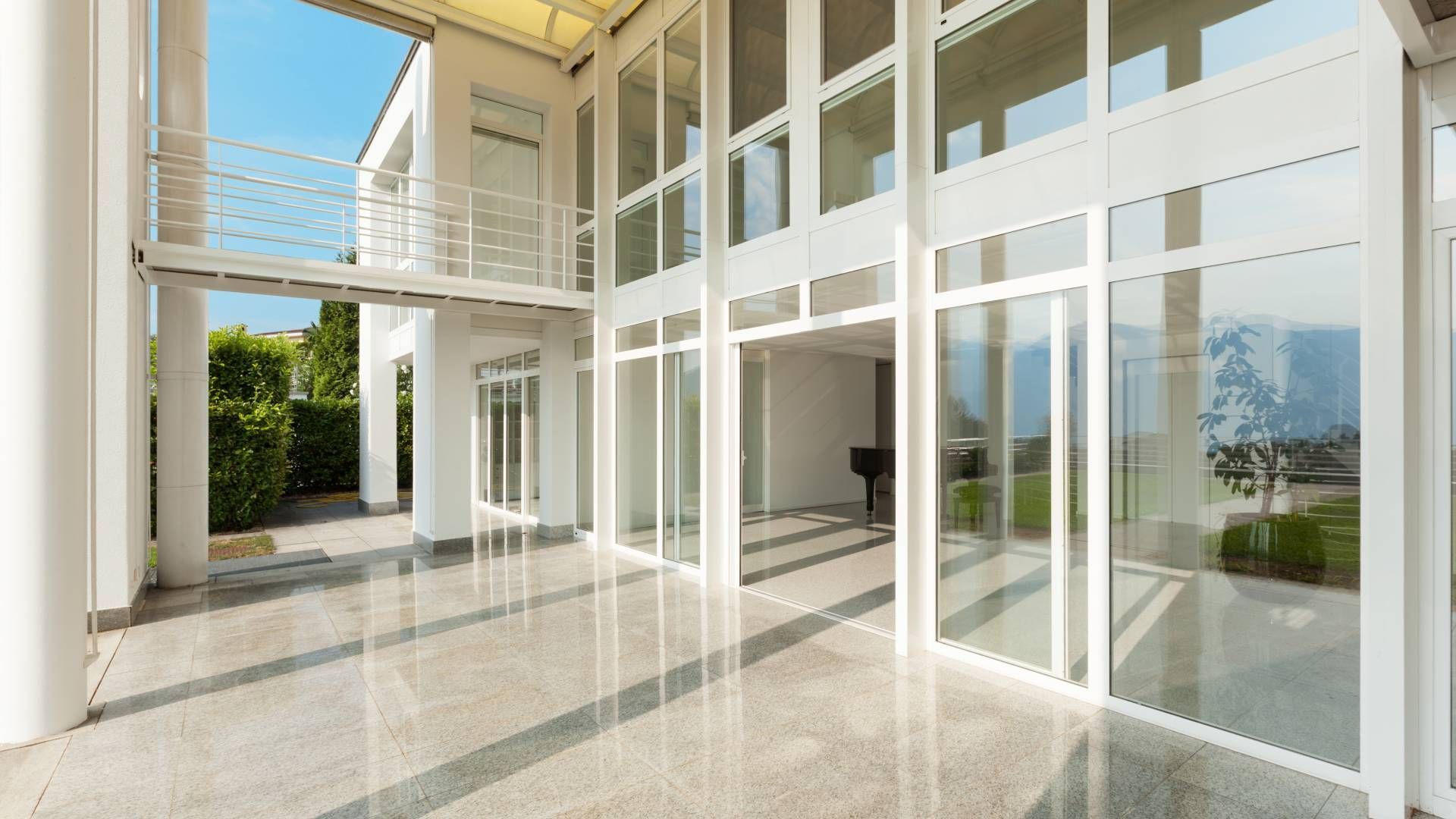 A large empty room with a lot of windows and a balcony.