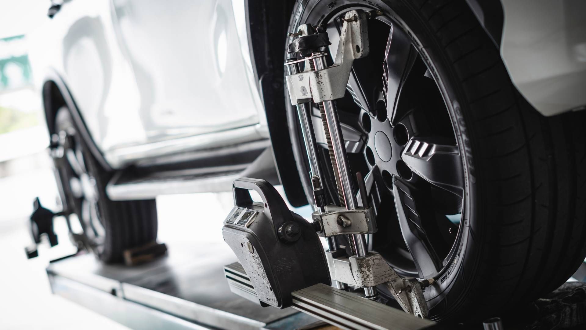 A car is being adjusted on a machine in a garage.