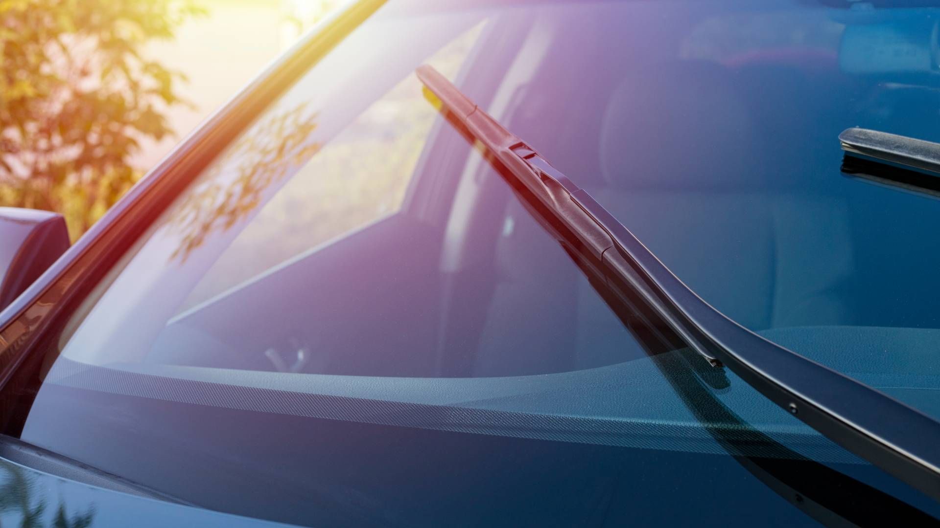 A close up of a car windshield with wiper blades on it.