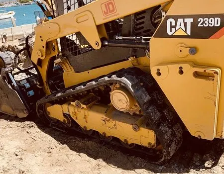 A cat 2390 bulldozer is parked in the sand