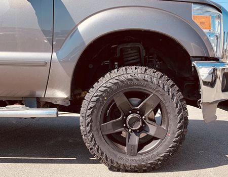A close up of a truck 's wheel and tire.