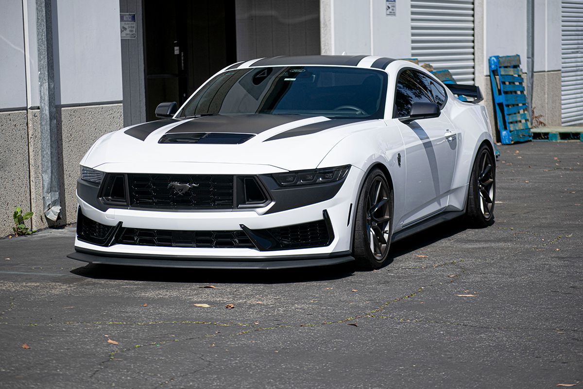 A gray ford mustang is parked in a parking lot.