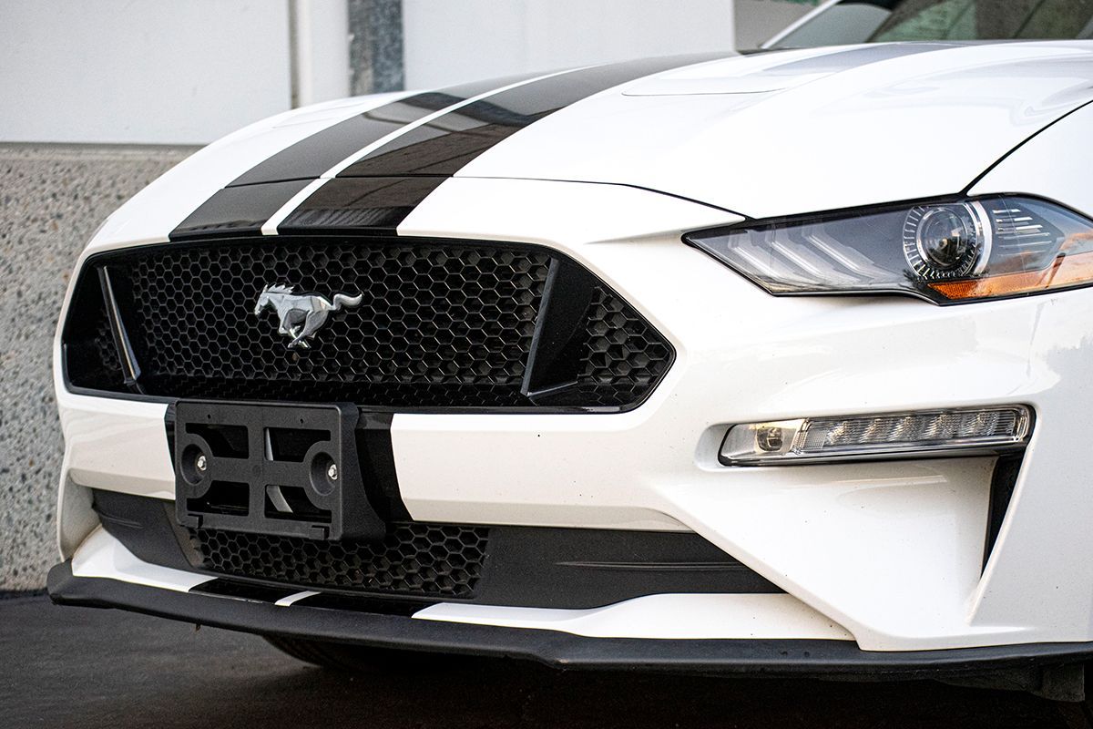 The back of a black ford mustang with a gt logo on it.