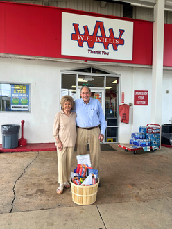 A man and a woman are holding basketballs in front of a store.