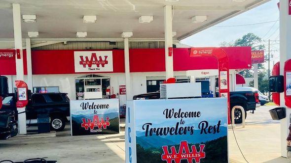 A gas station with a sign that says welcome travelers rest.