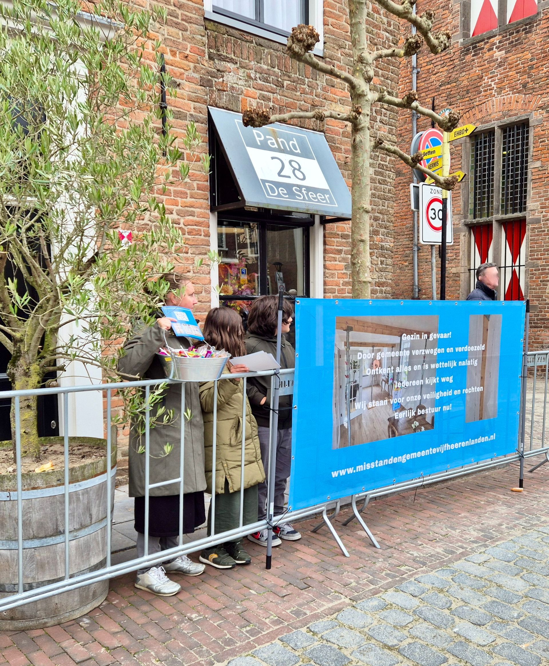 Twee tenten staan voor een bakstenen gebouw.