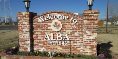 A brick sign that says welcome to alba est 1845