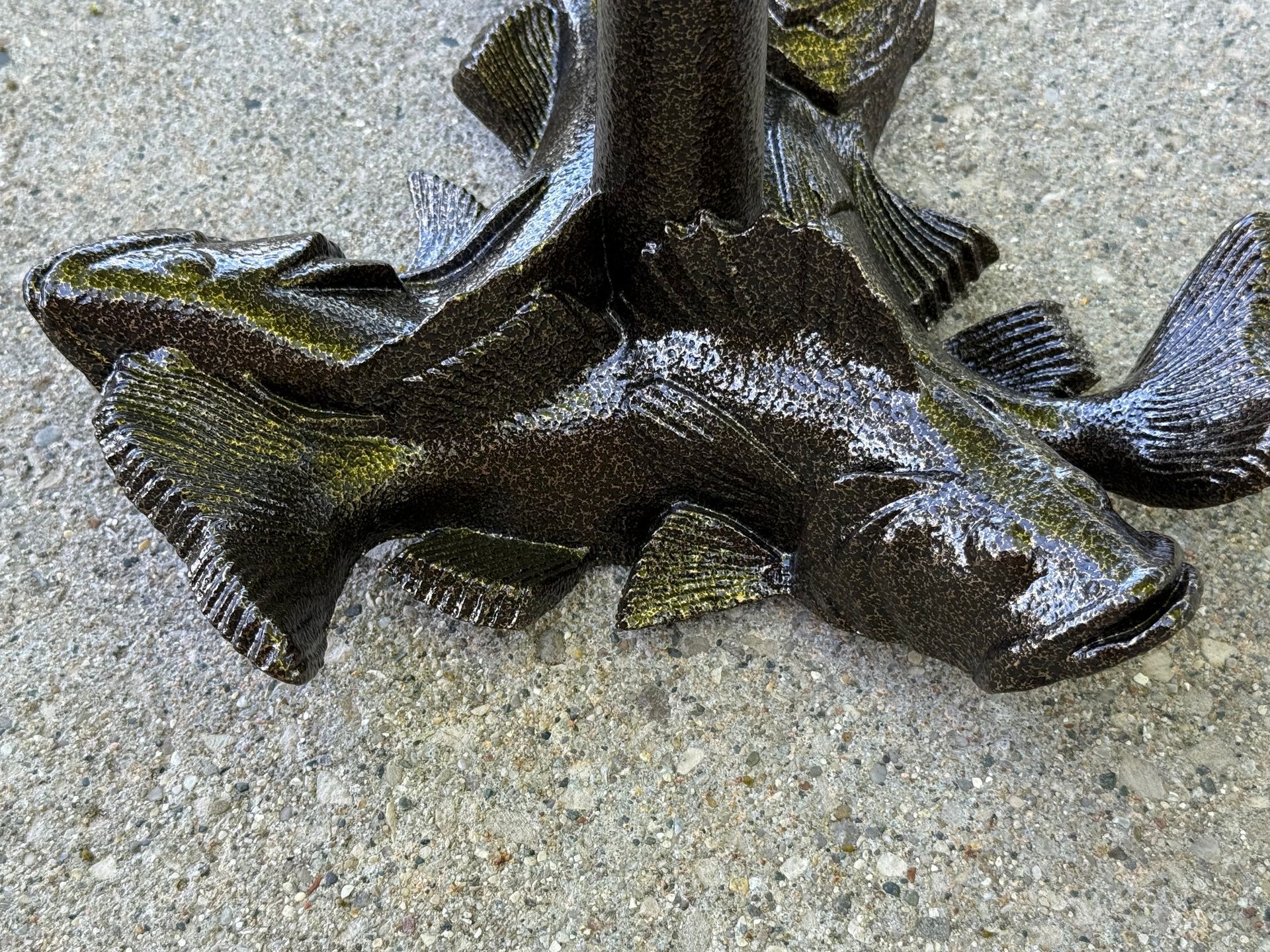 Dark bronze metal sculpture with abstract, winged shapes on a textured surface