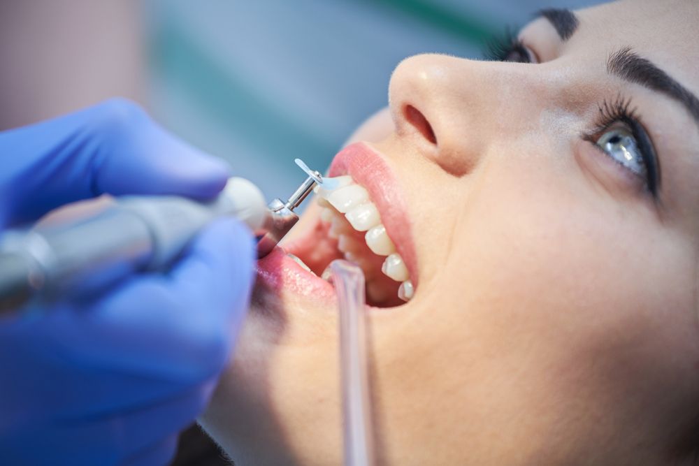 A Woman is Getting Her Teeth Cleaned by a Dentist — Cairns Precision Dental Group In Woree, QLD