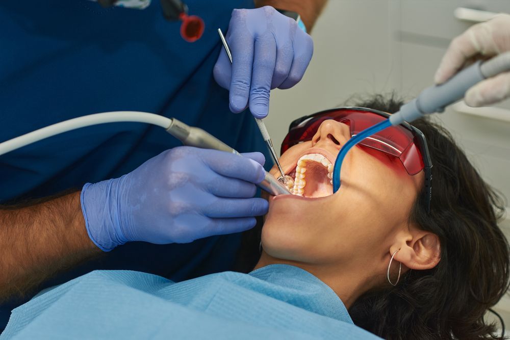 A Woman Is Getting Her Teeth Examined By A Dentist — Cairns Precision Dental Group In Woree, QLD