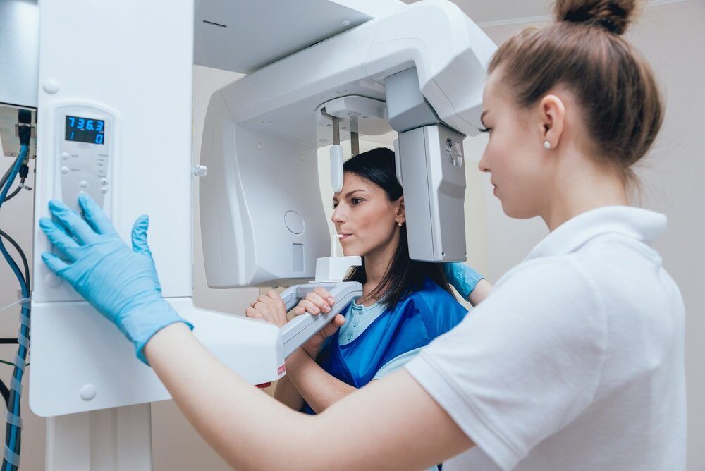 A Woman is Getting an X-ray of Her Teeth in a Dental Office — Cairns Precision Dental Group In Woree, QLD