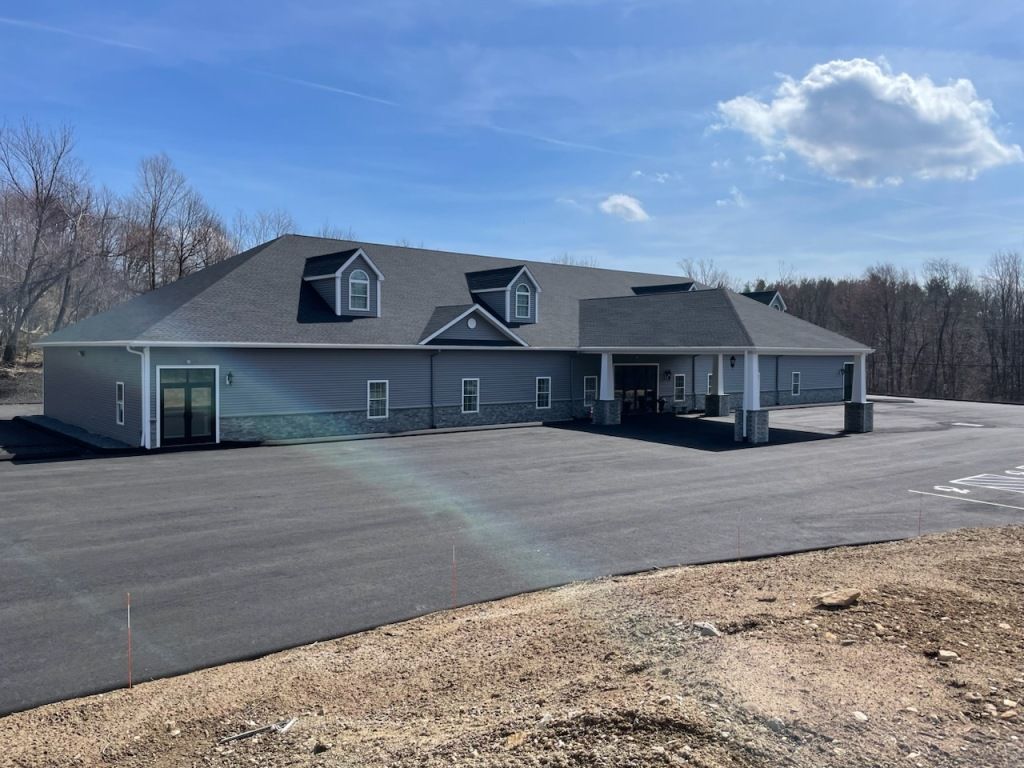 A large house with a parking lot in front of it