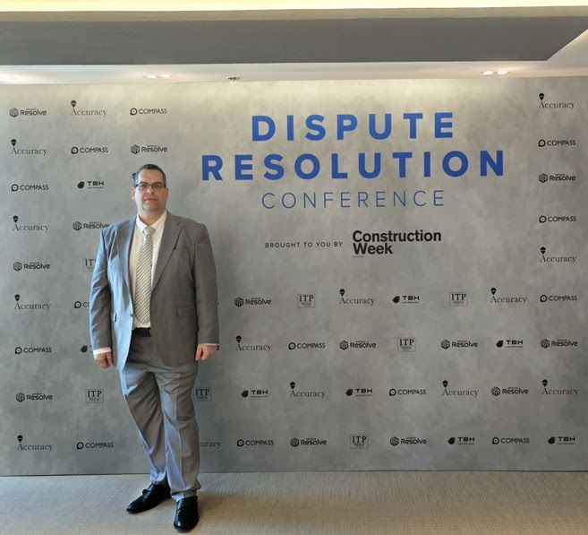 Man in a gray suit stands at a 