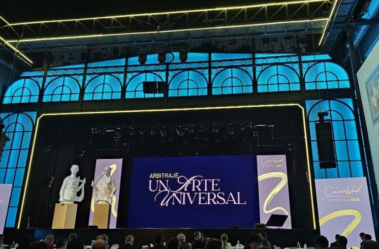 Stage with blue arched windows, artwork displays, large screen with text 