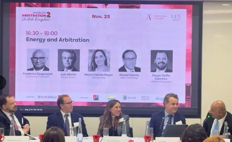 Panel discussion: Energy and Arbitration. Five panelists in front of a screen with speakers' names, November 25.