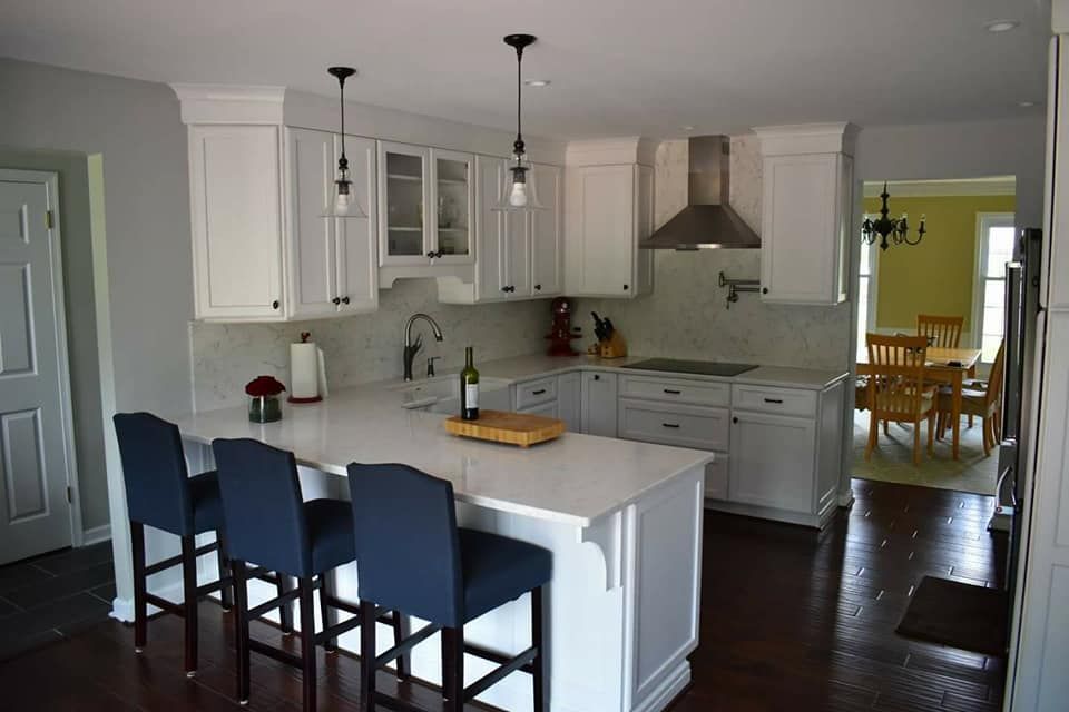 A kitchen with white cabinets and blue bar stools