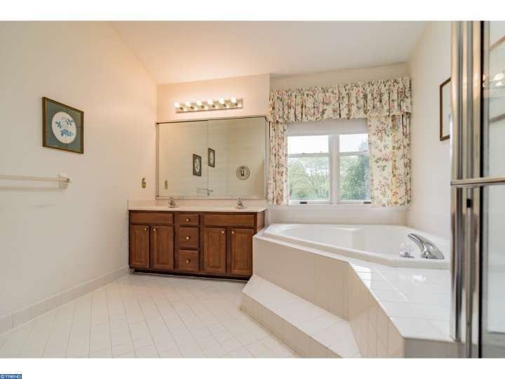 A bathroom with two sinks and a tub.