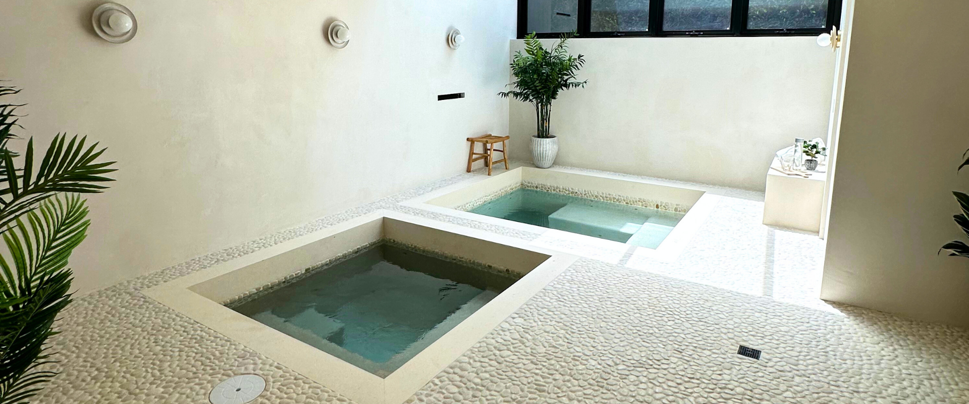 Swimming pool with white deck and furniture in an outdoor setting.