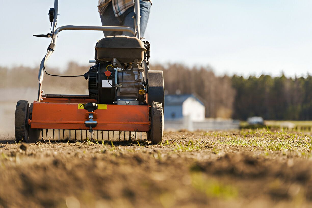 A person is using a lawn mower to spread fertilizer on a field.