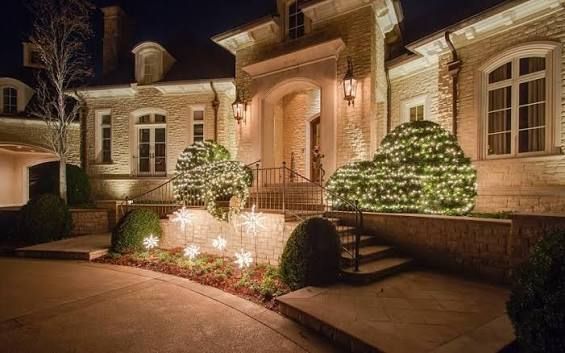 Atlanta mansion entrance at night, lit by warm landscape lights and trimmed hedges