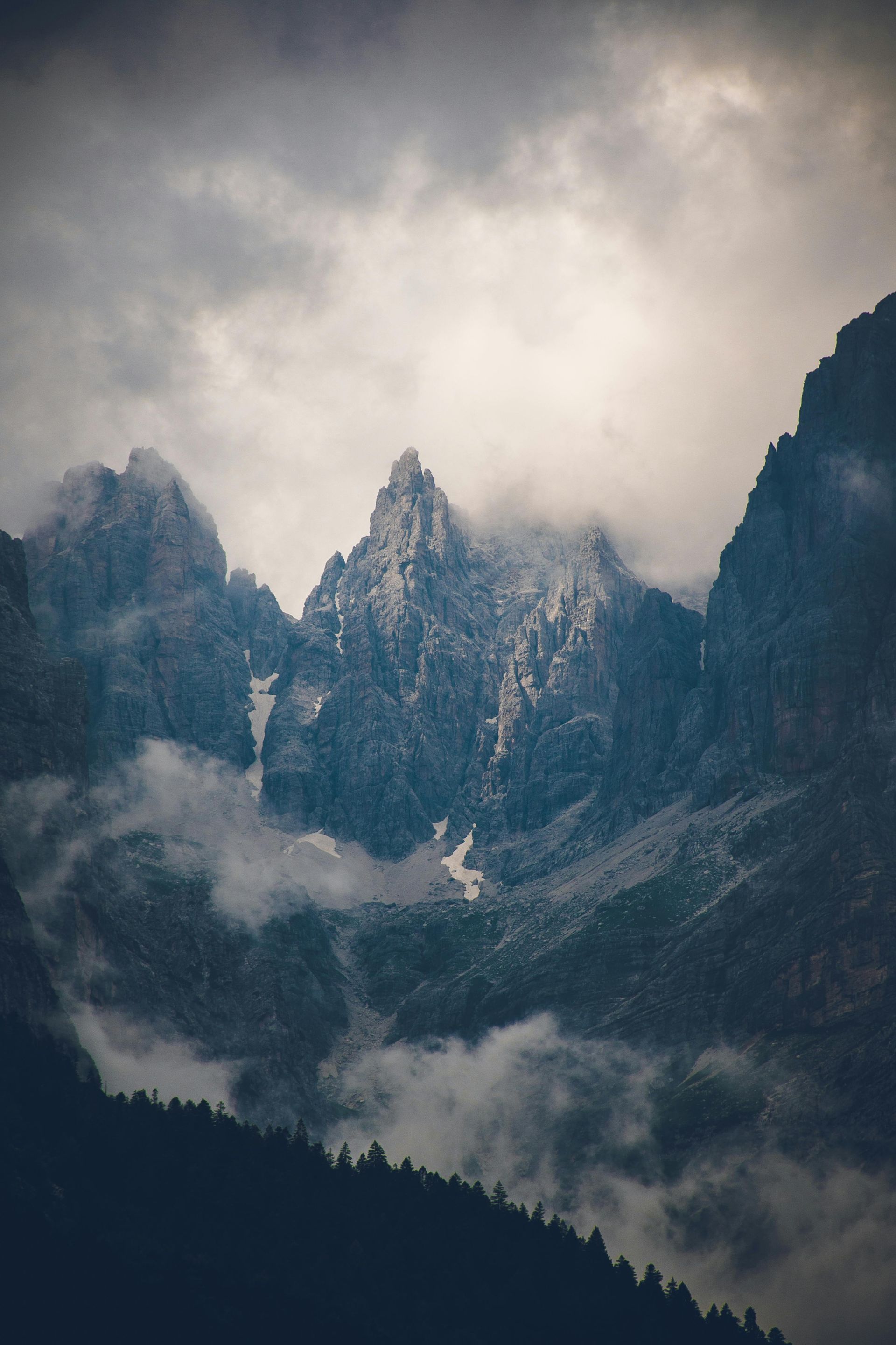 A mountain covered in snow and clouds on a cloudy day