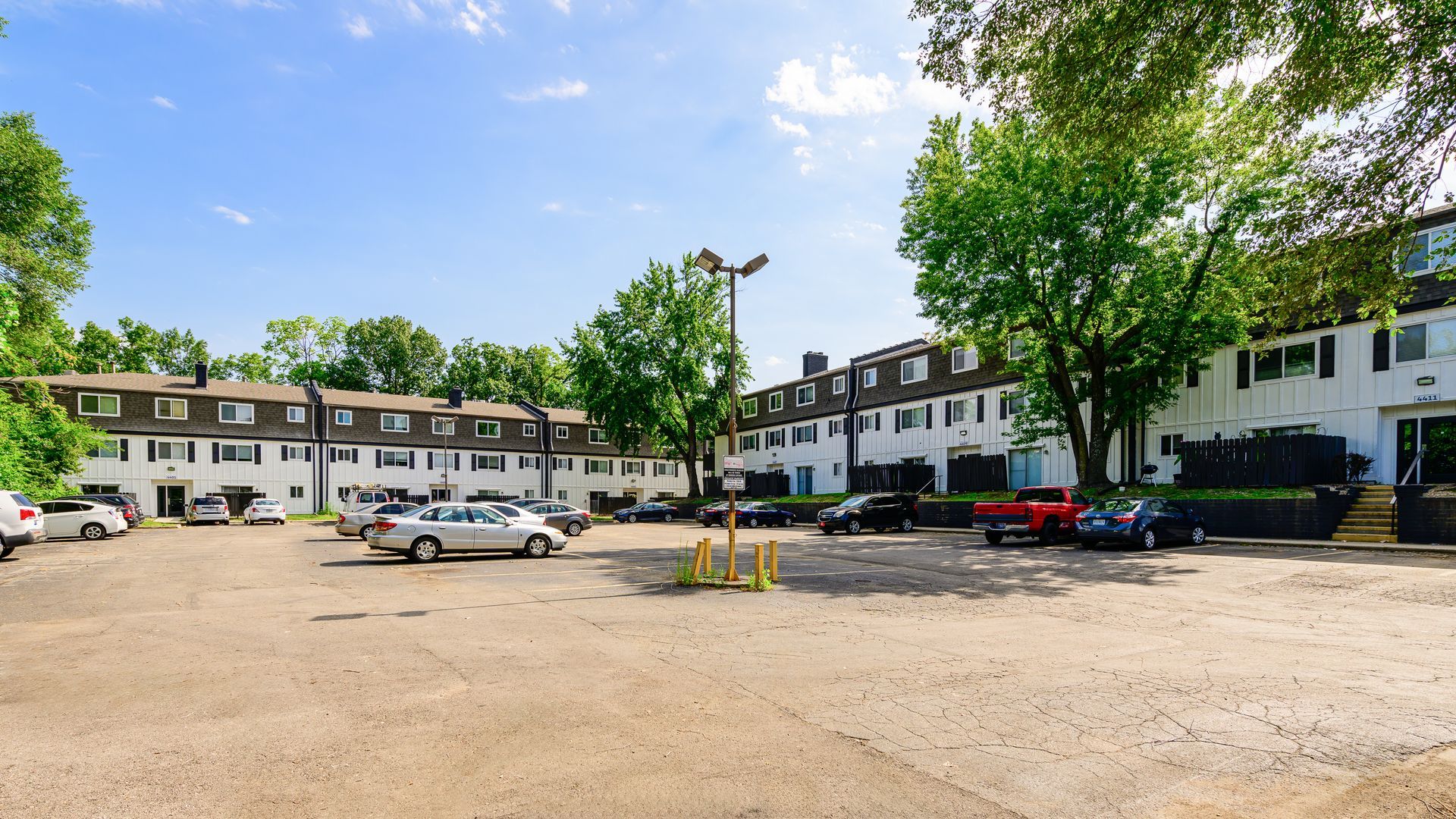 A parking lot with cars parked in front of a building.