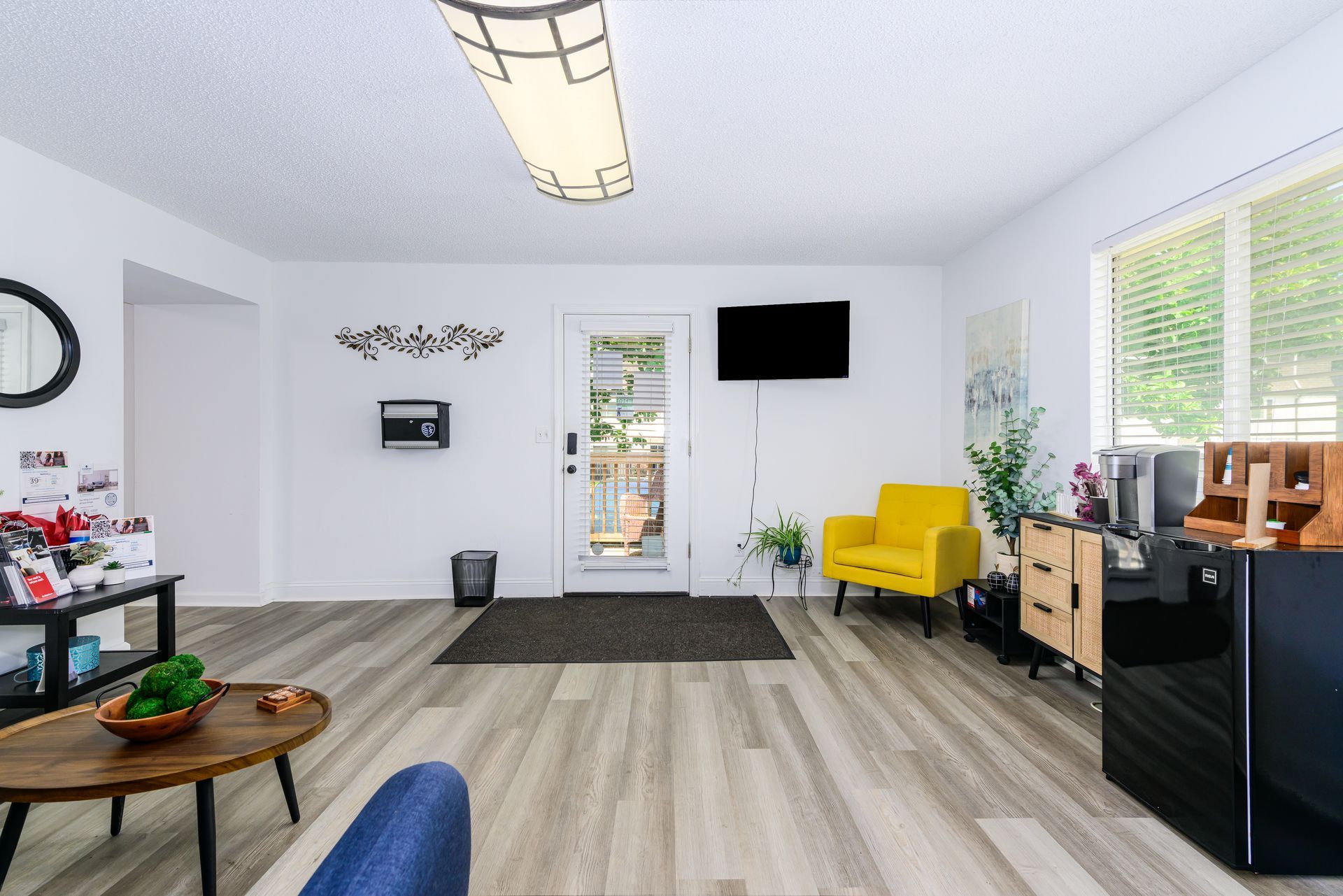 A living room with hardwood floors and a yellow chair