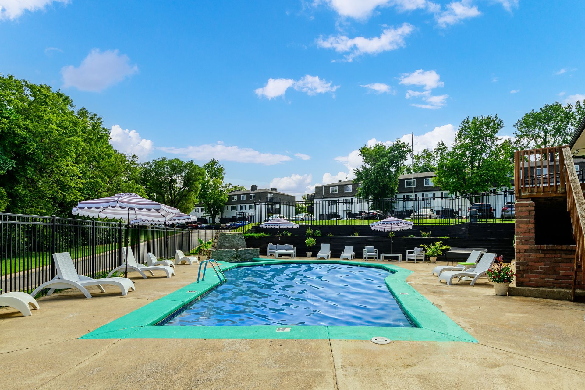 A large swimming pool with chairs and umbrellas around it