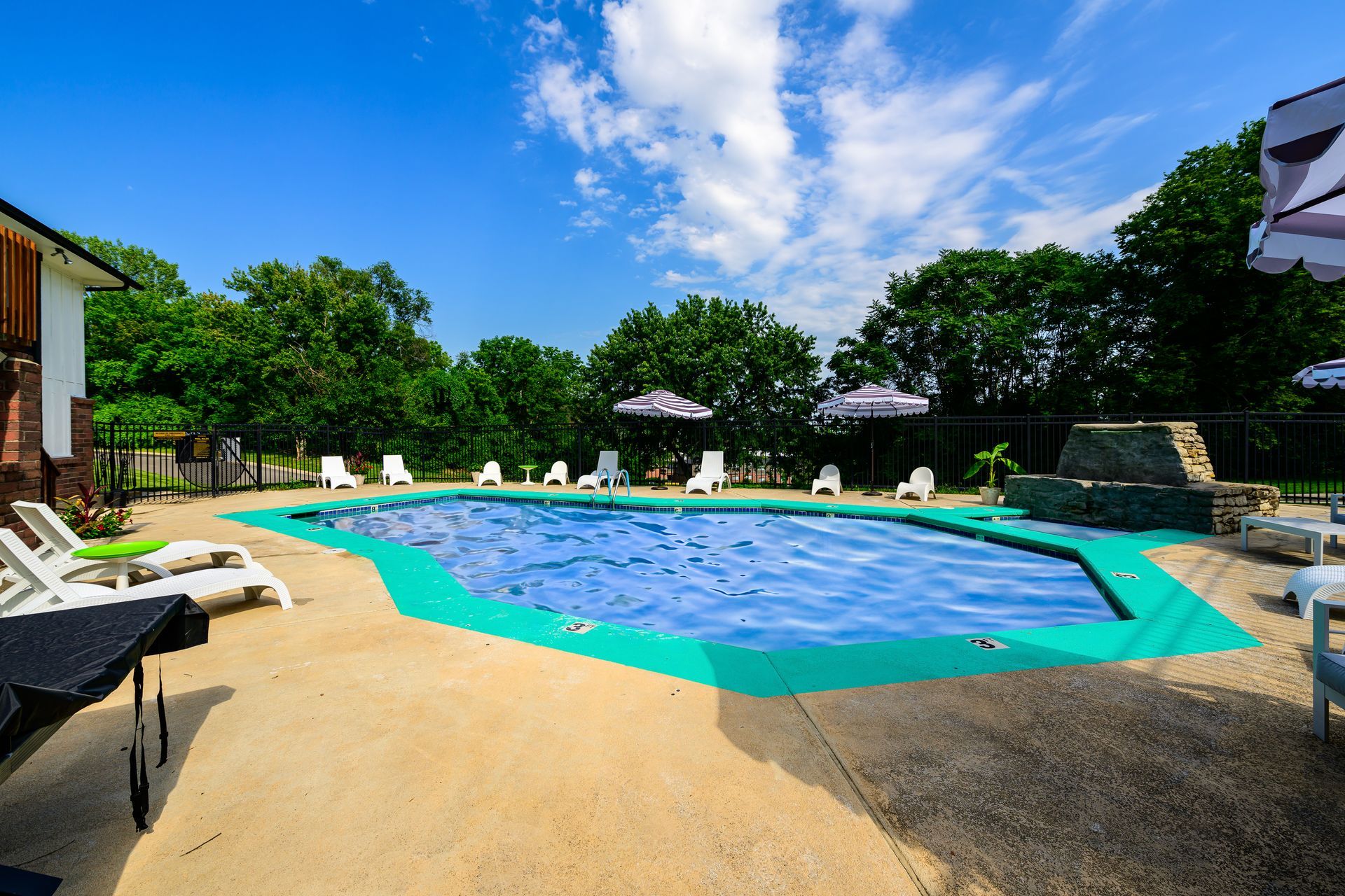 A large swimming pool surrounded by chairs and umbrellas