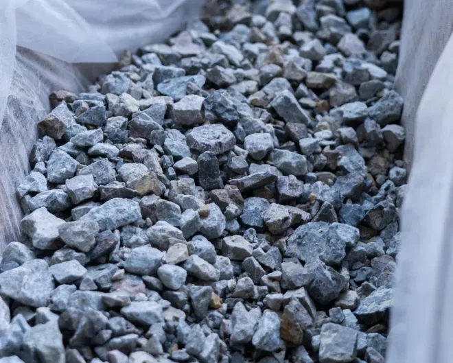 Gray crushed stones filling a white woven bulk bag