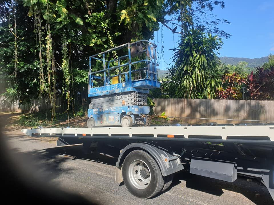 Blue Scissor Lift on a Flatbed Truck Near Lush Greenery — Tigo’s Towing In Cairns City, QLD