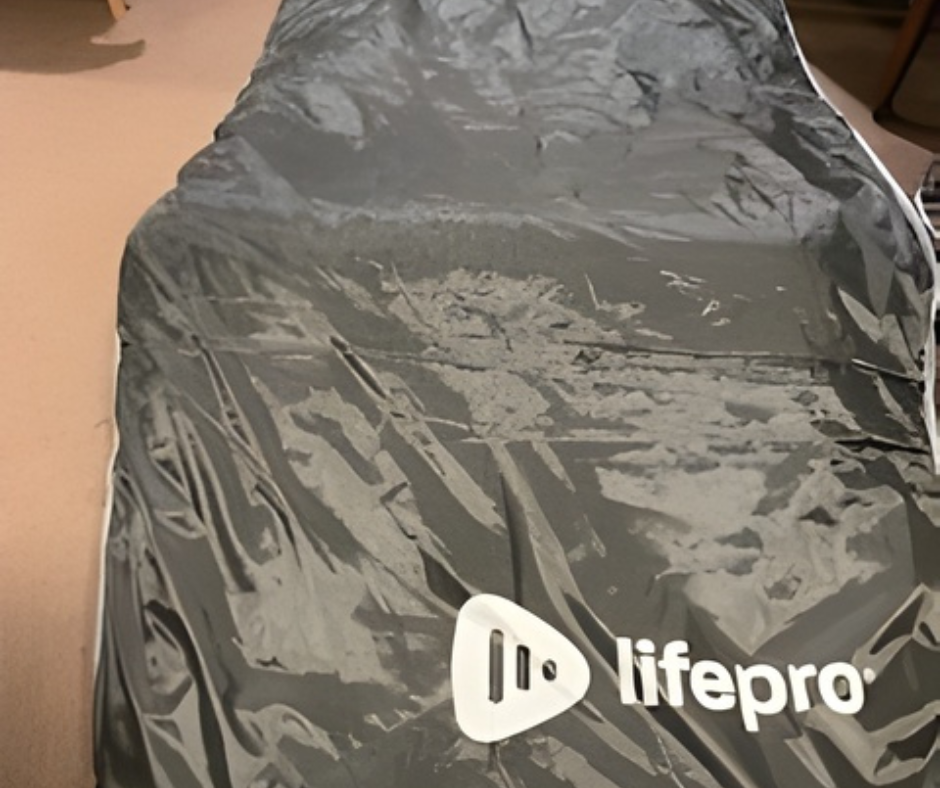 A dark gray Lifepro weighted blanket resting on a beige surface.