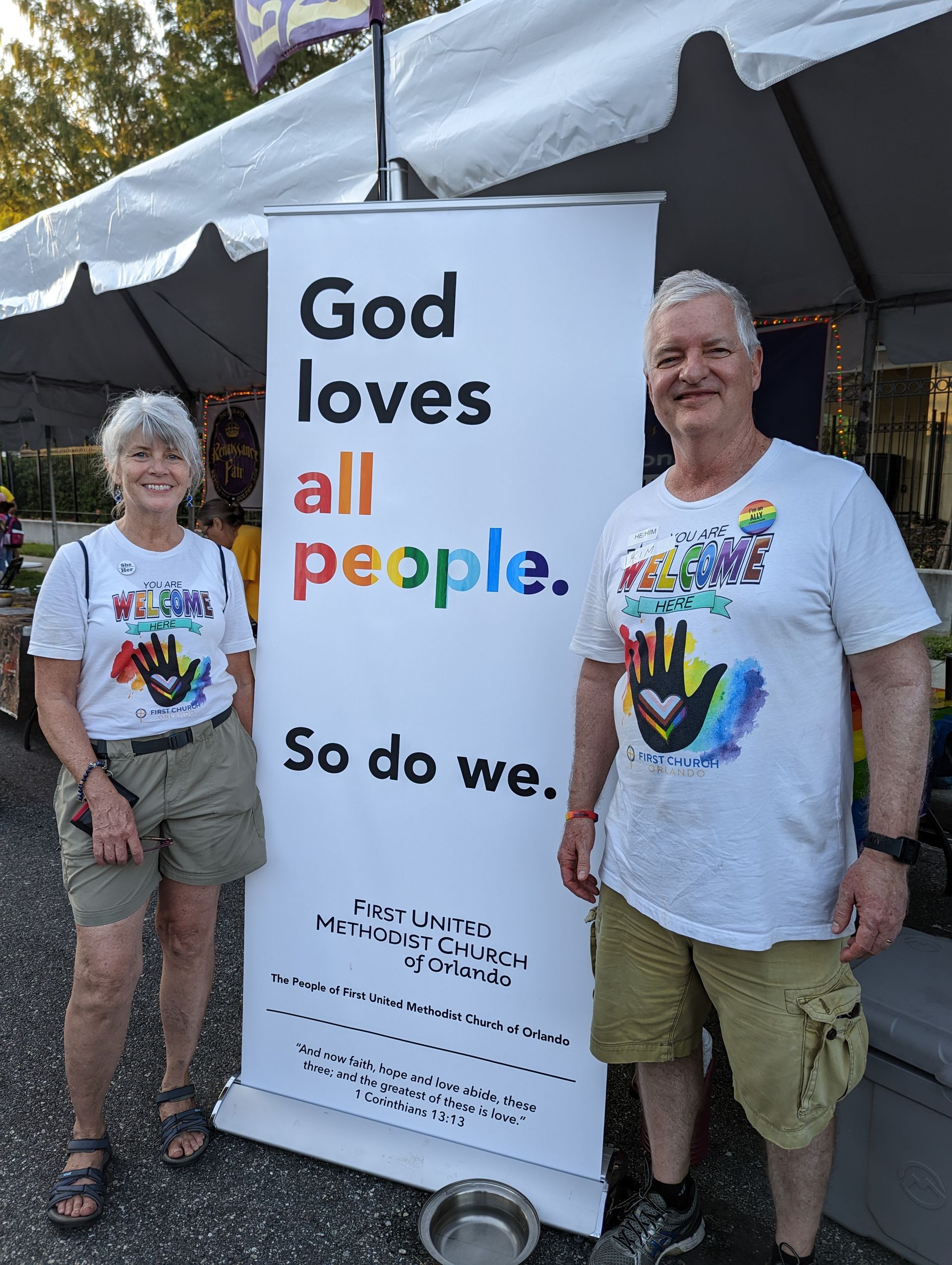 Two people stand by a sign: