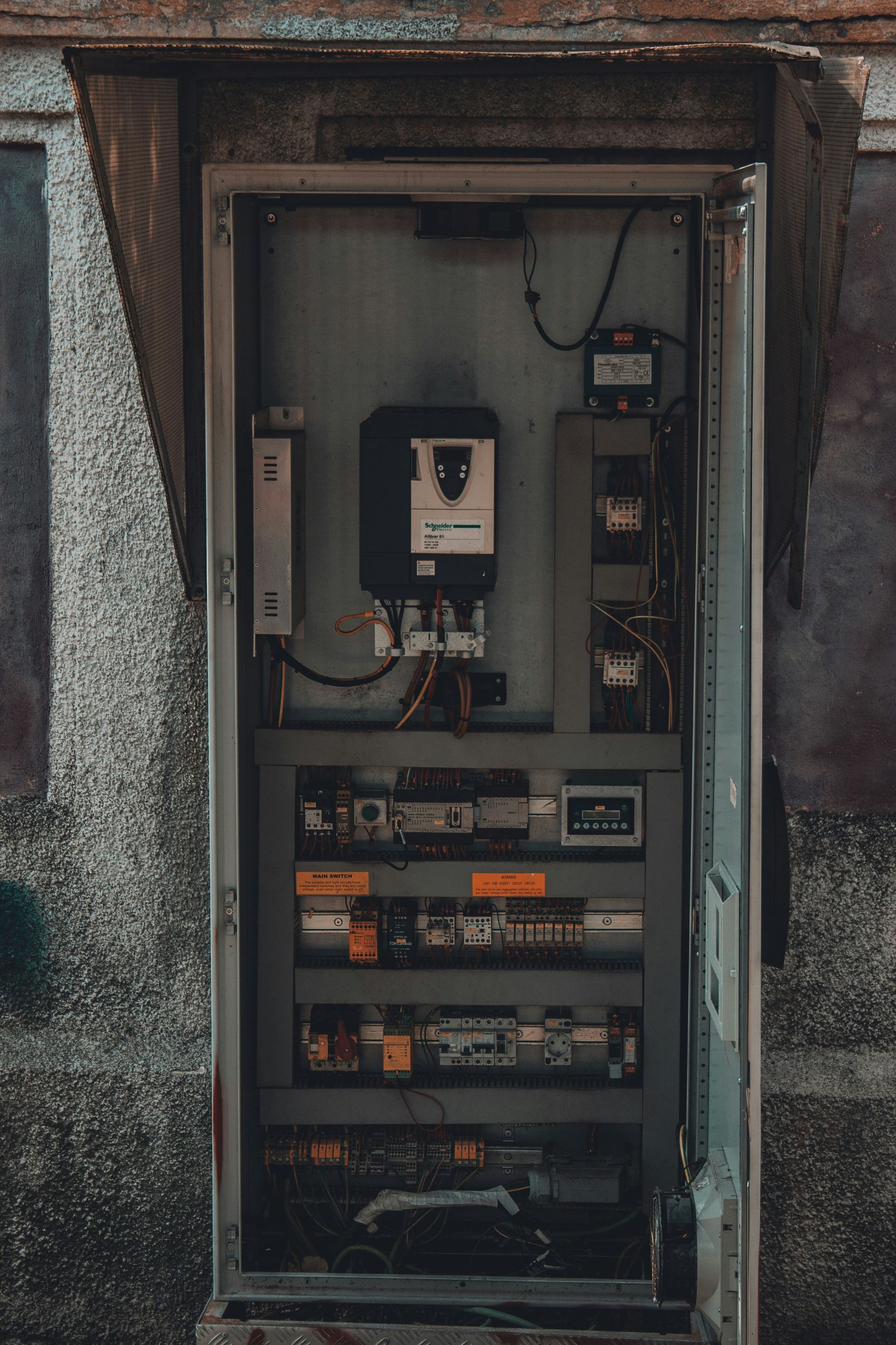 A very old electrical box with a lot of wires coming out of it.