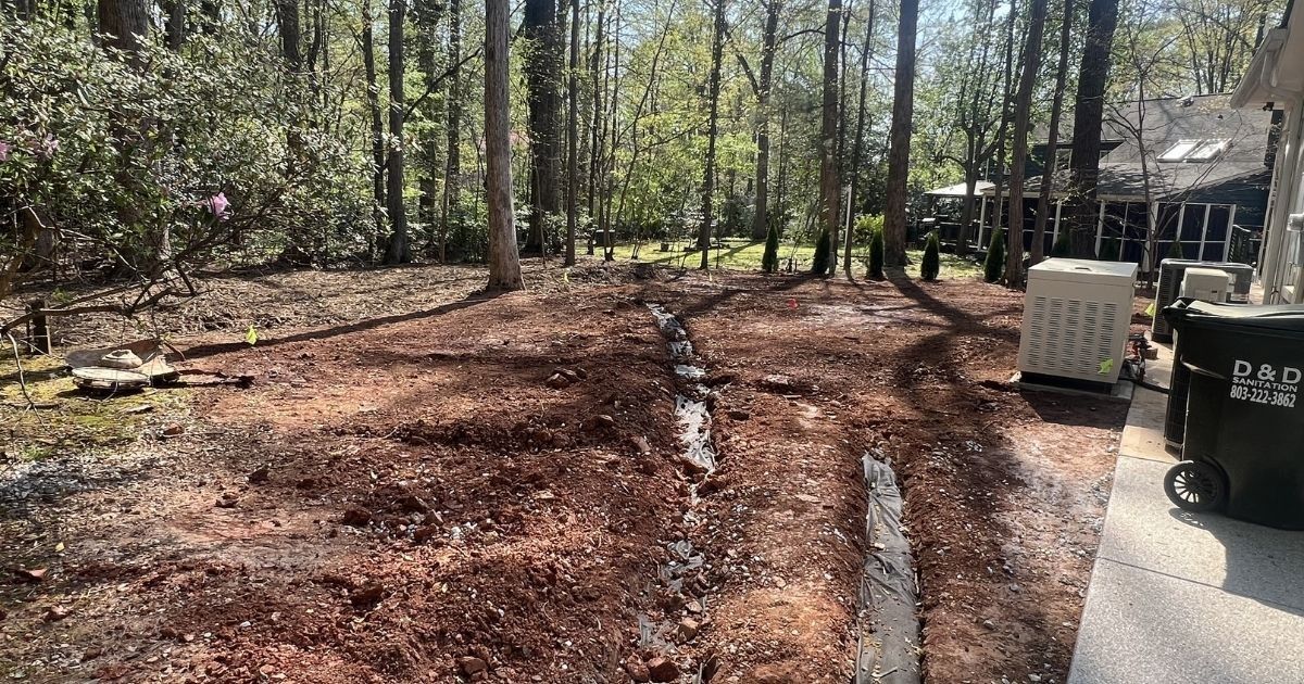 Decorative concrete curbing and river rock around poolside landscape beds in Clover SC