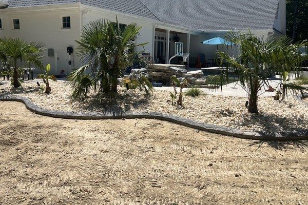 Back yard transformation in progress - curbing, shrubbery, and rock
