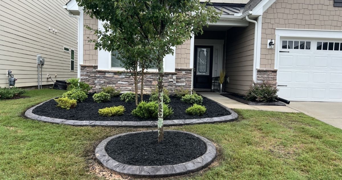 Front of home with mulch beds and decorative curbing