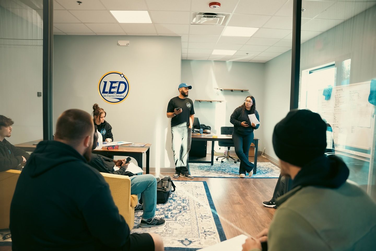 Group in a meeting, one person speaking, logo for