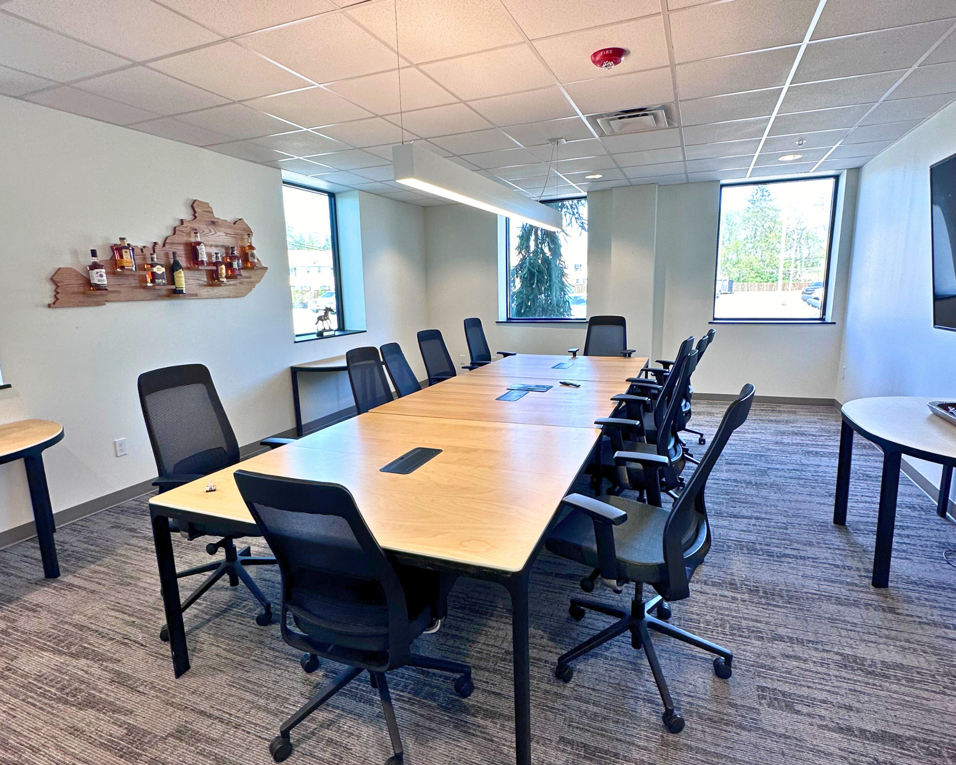 Conference room with long table, black chairs, and Kentucky artwork on the wall.