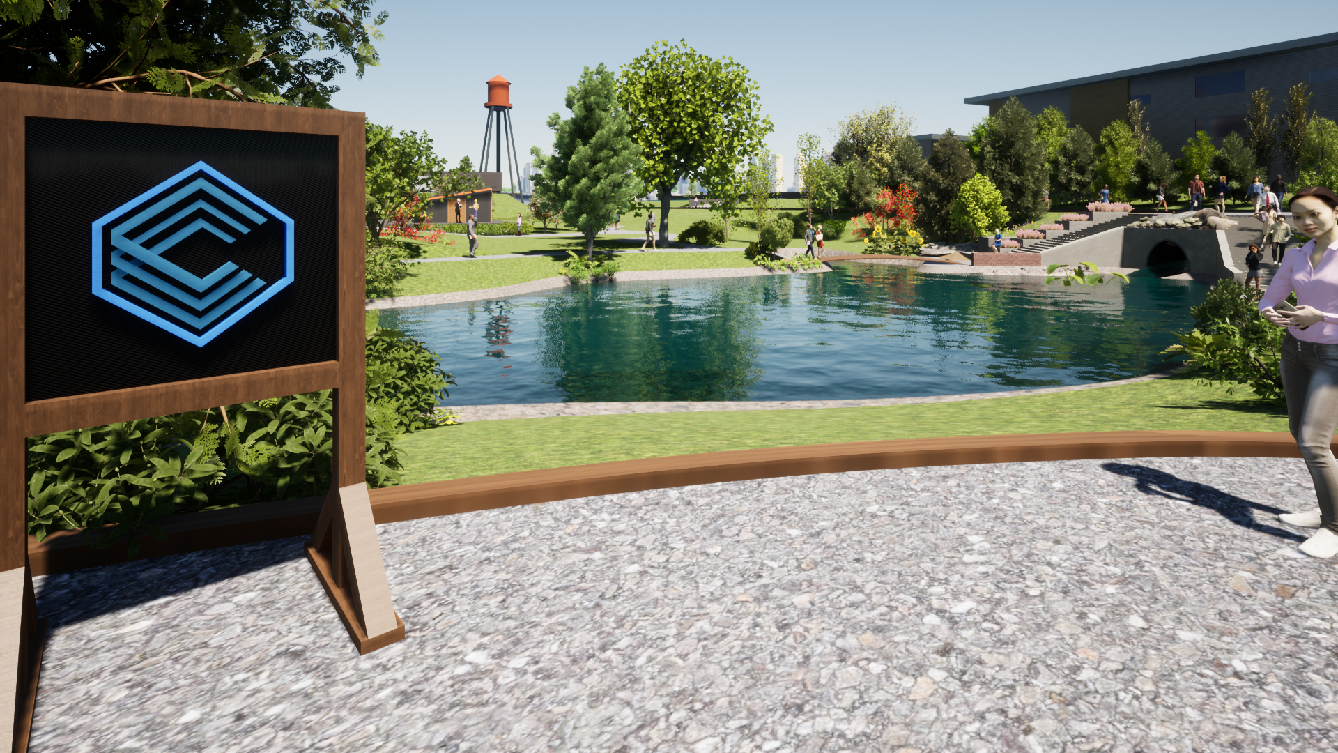 A sign with a logo stands near a lake, a person stands nearby in a sunny outdoor setting.