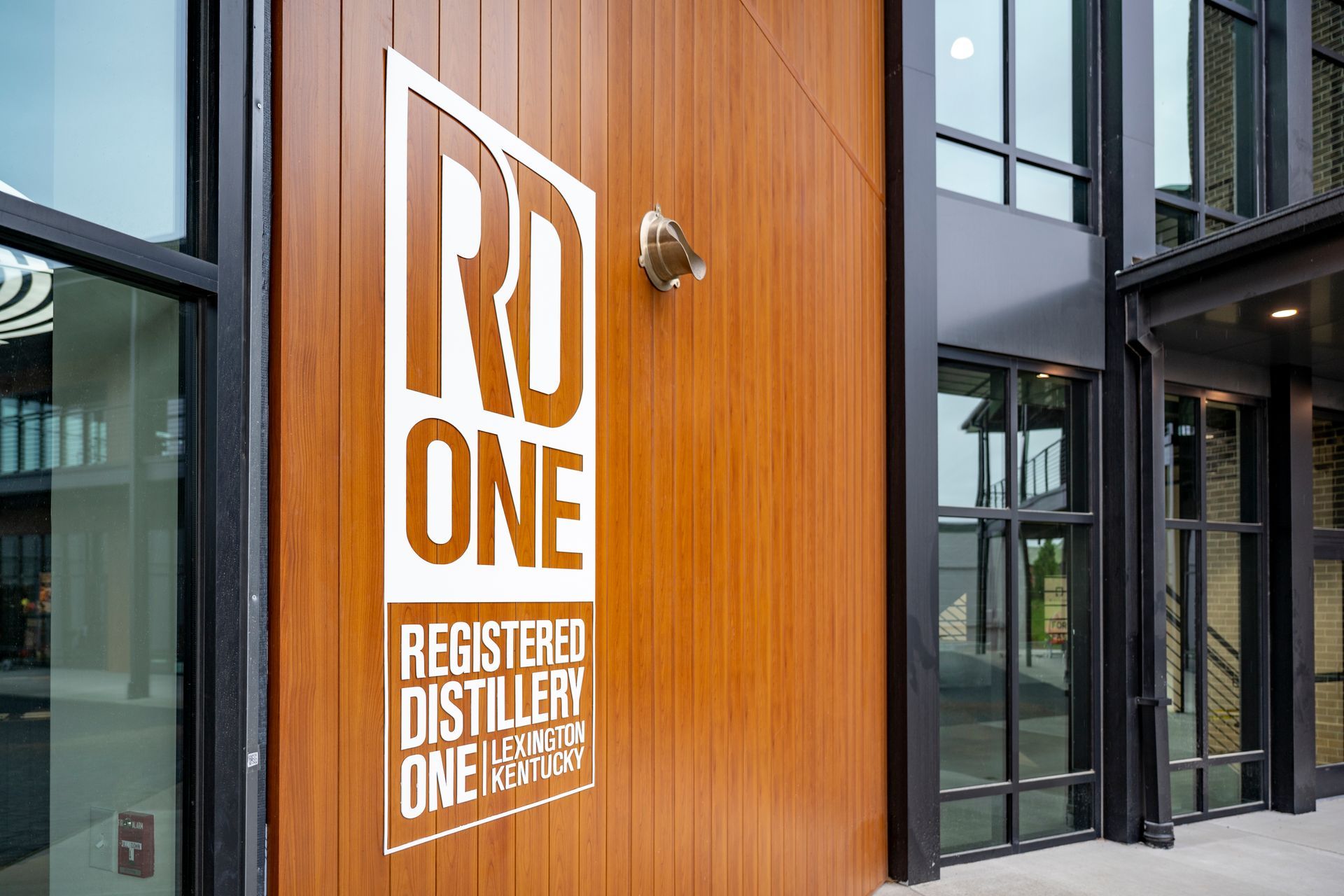 RD One Distillery sign on a wooden building exterior with glass windows.