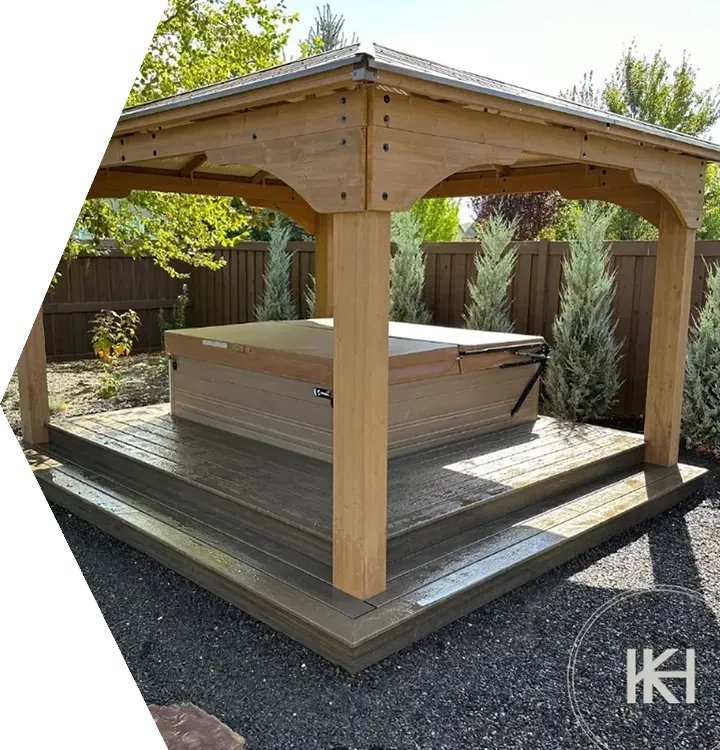 Wooden gazebo covering an outdoor hot tub on a raised deck in a garden