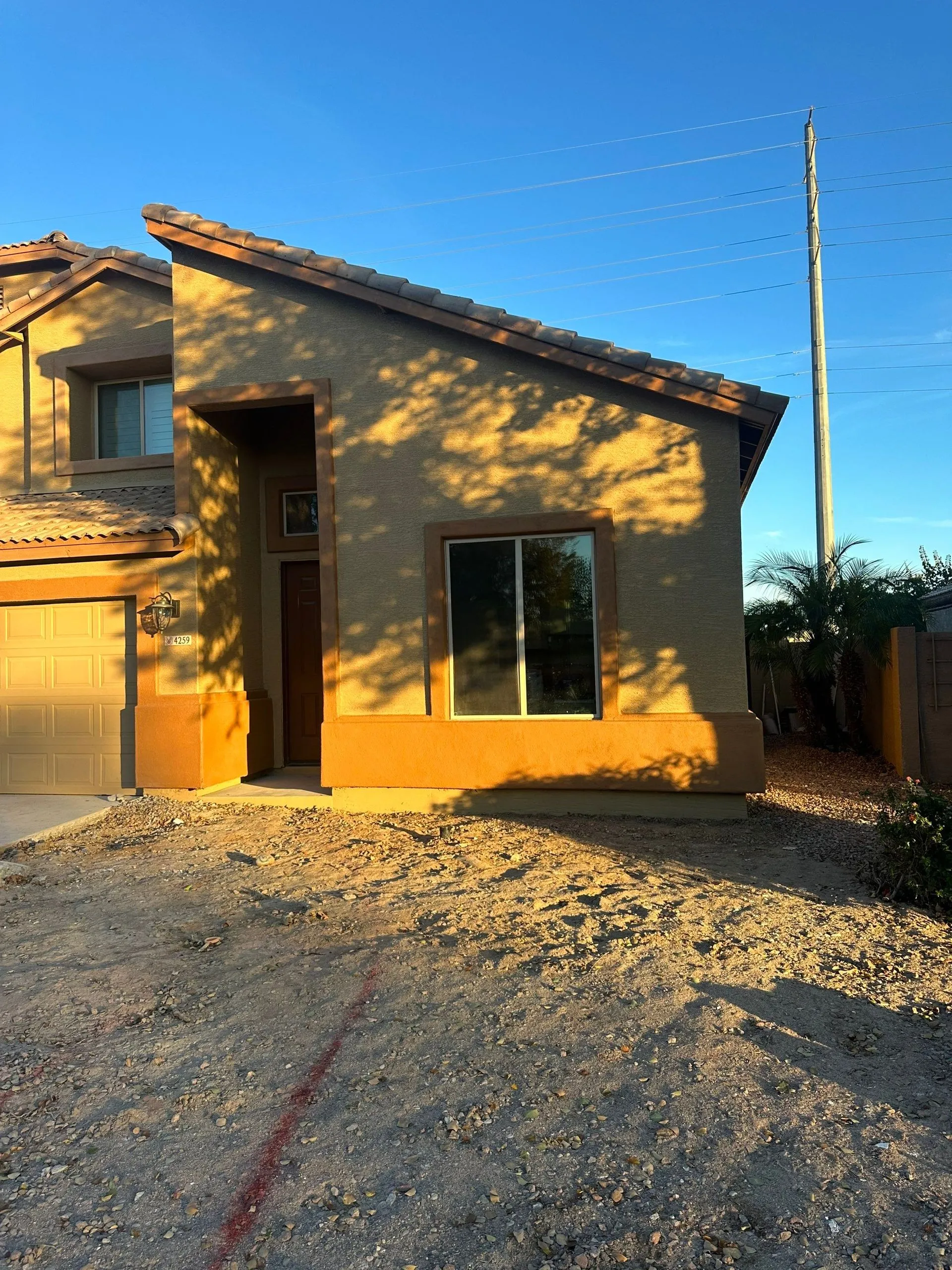 A house with a garage and a blue sky in the background.