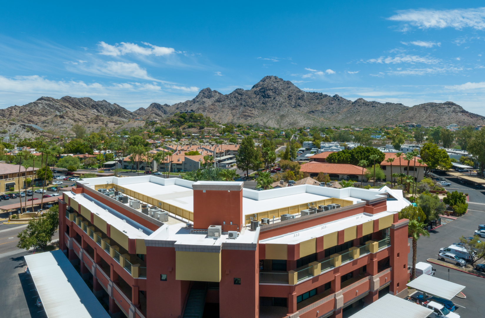 An aerial view of a parking garage with mountains in the background.