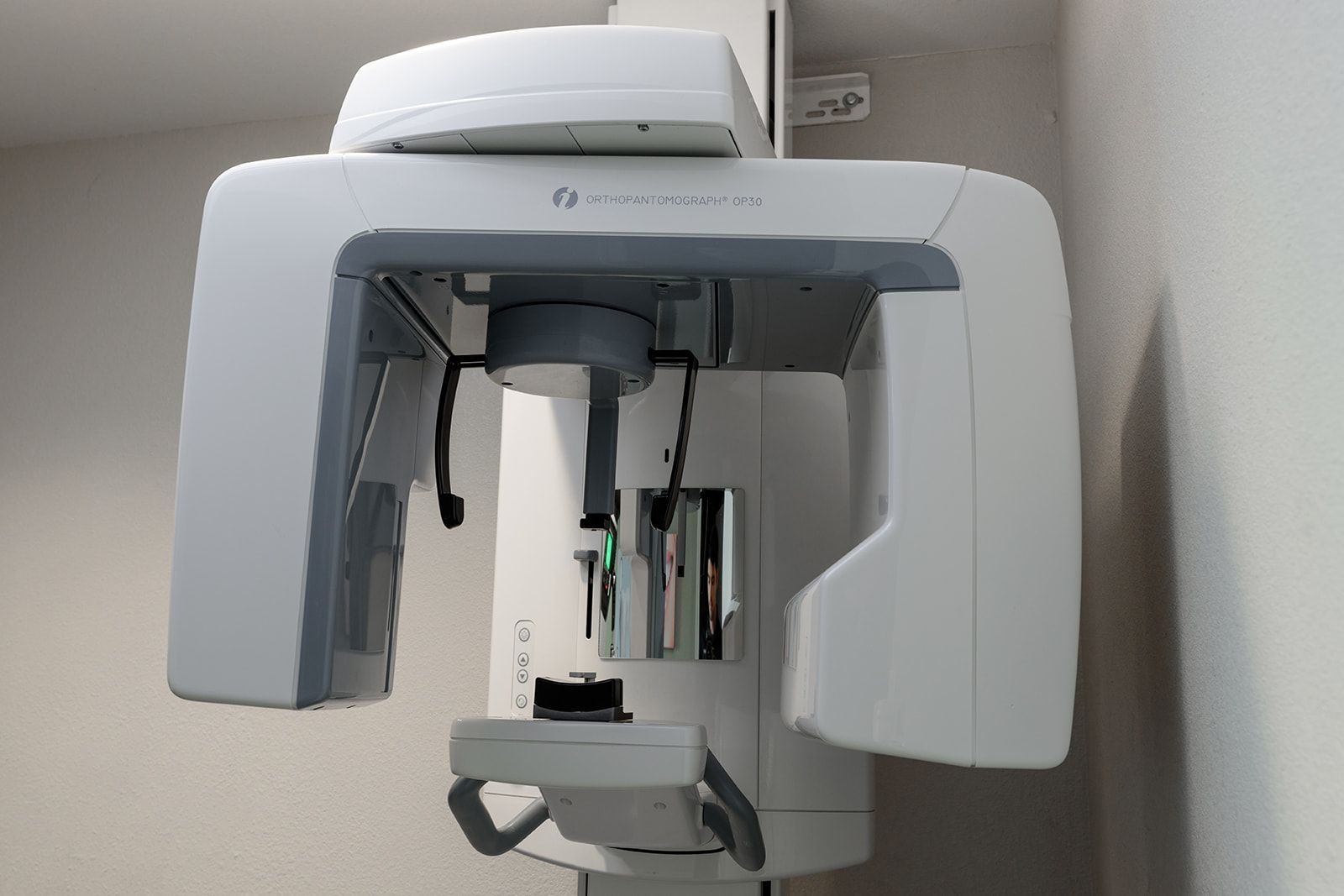 A dental x-ray machine is hanging from the ceiling in a dental office.