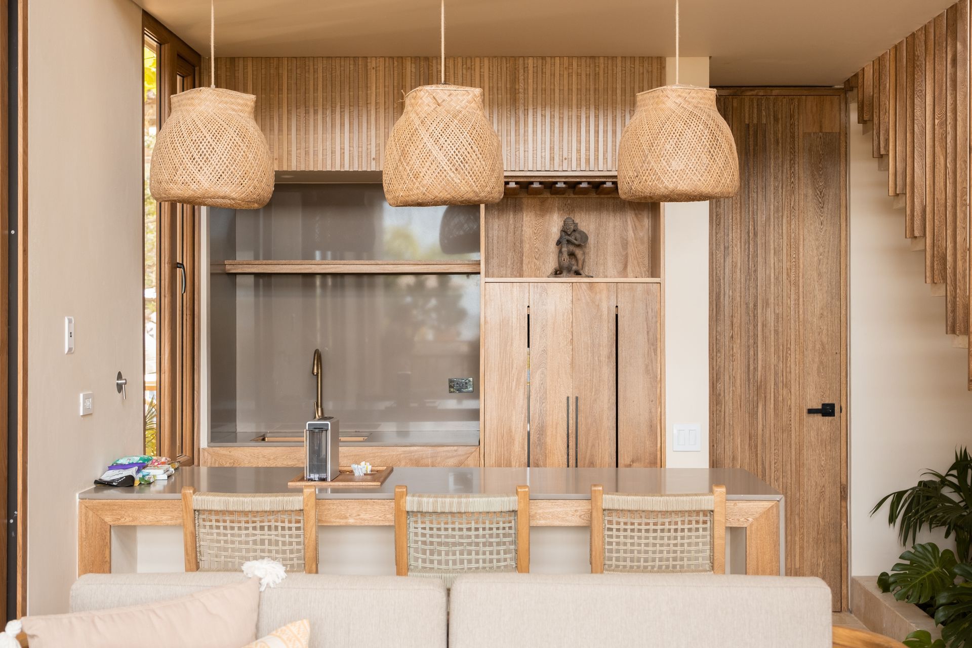Accommodation in San Antero with wooden table, woven lamps, open kitchen, and interior staircase.