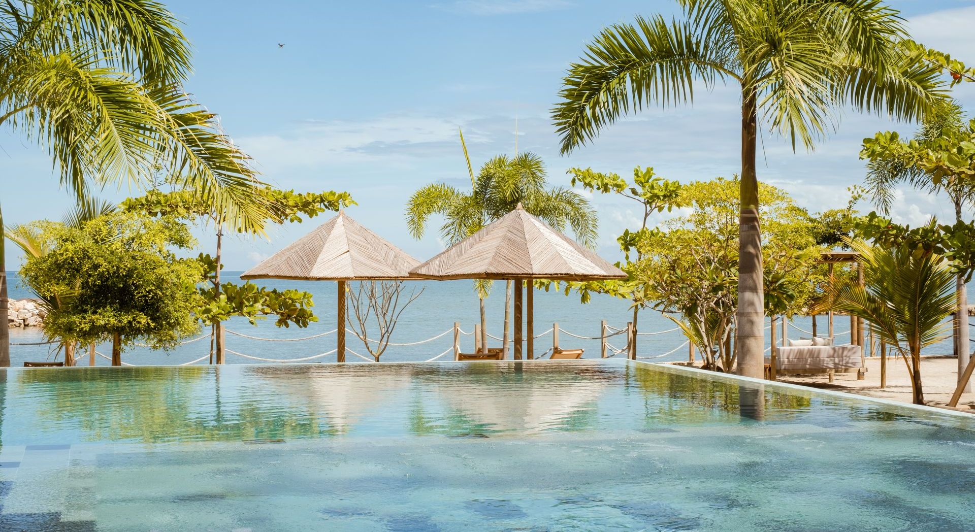 Hotel with pool in Colombia, featuring ocean views, palm trees, and a peaceful setting in Punta Bolívar.